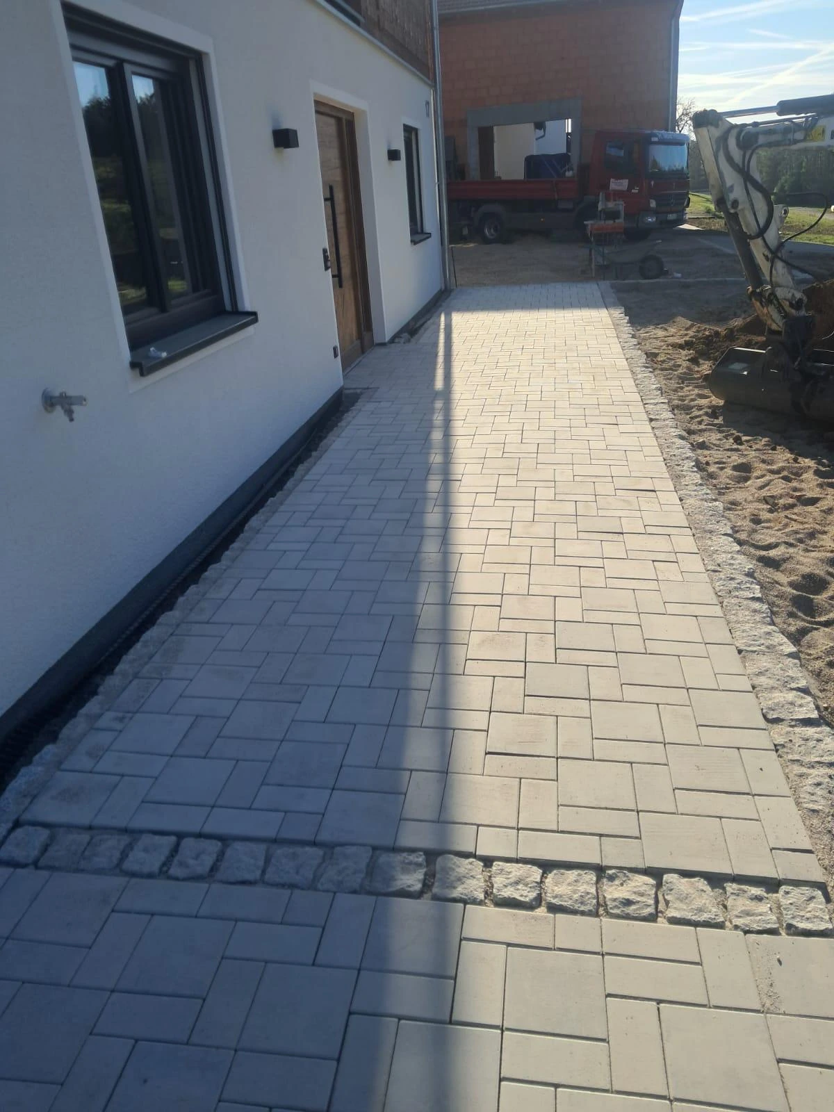 Gepflasterter Hausweg entlang einer Fassade